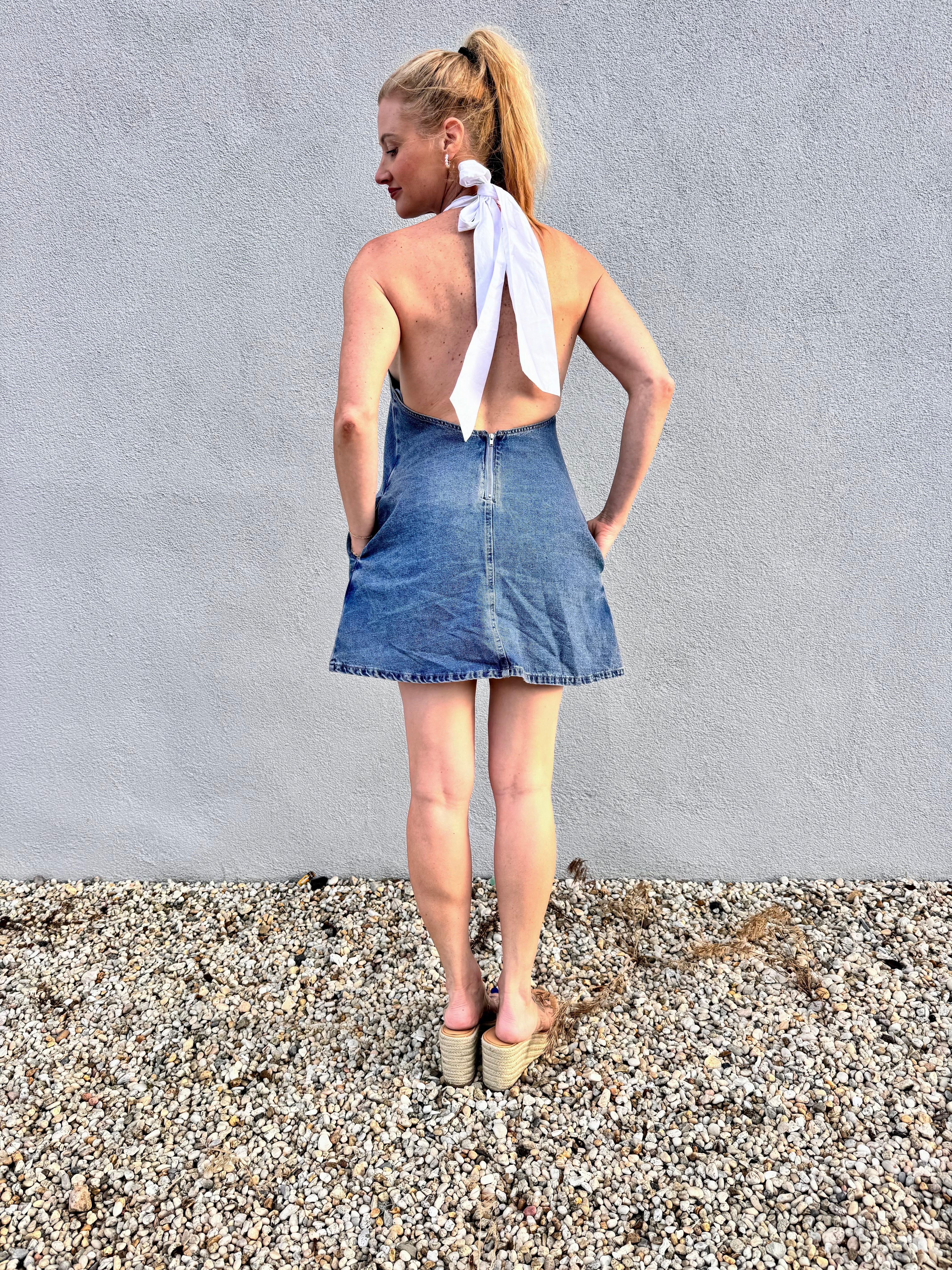 lifehouse denim halter dress Cult Gaia Charo Zip Mini Our Isalin Mid Wash Denim Halter Mini Dress features a deep low V Already Iconic Halter Denim Mini
